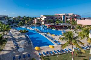 Muthu Playa Varadero Hotel mit großem Pool und vielen Liegestühlen und Palmen.