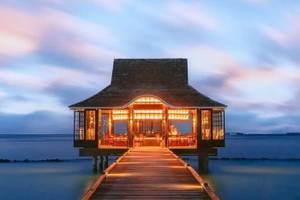 Nova Maldives Resort bei Nacht mit beleuchtetem Steg und illuminiertem Eingang