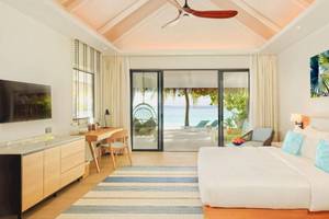 Ein Schlafzimmer im Nova Maldives Hotel mit Blick auf das Meer und eine Terrasse.