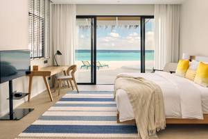 Hotelzimmer im Nova Maldives mit Meerblick, Bett, Schreibtisch und Fernseher.