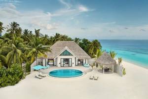 Luftaufnahme der Nova Maldives Villa mit Pool und Sonnenliegen auf dem Strand.