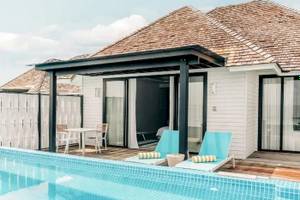 Außenbereich des Nova Maldives Hotels mit Pool und Lounge-Bereich.