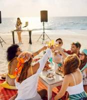 Gruppe von Freunden genießt eine Strandparty im Nova Maldives Hotel
