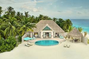 Luftaufnahme des Nova Maldives Resorts mit einer privaten Villa, Swimmingpool und Sonnenliegen am Strand.