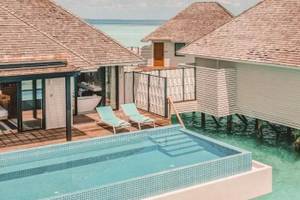 Nova Maldives Hotel Pool-Villa mit zwei Liegen und Badewanne am Meer.