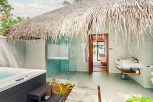 Ein Freiluft-Badezimmer mit Badewanne, Dusche und Waschbecken im Nova Maldives Hotel.