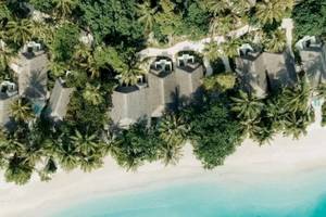 Obersflächlicher Blick auf das Nova Maldives Hotel mit weißen Stränden und blauem Wasser.