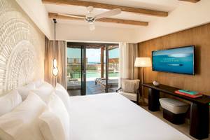 Hotelzimmer im Mitsis Selection Rinela mit Doppelbett, Fernseher und Poolblick.