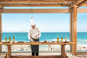 Koch in Mitsis Selection Rinela bereitet Essen zu, Blick auf das Meer