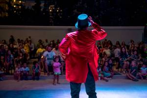 Magier in rotem Mantel und Hut führt eine Show im Mitsis Selection Rinela Hotel vor einem Publikum vor.