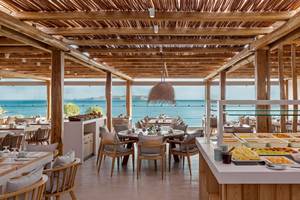 Innenansicht des Restaurants im Mitsis Selection Rinela Hotel mit Blick auf das Meer.