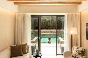 Wohnbereich im Mitsis Selection Rinela Hotel mit Blick auf den Poolbereich.