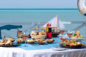 Meerblick-Tisch im Mövenpick Resort & Spa El Gouna mit vielen Gerichten, Gläsern und Dekoration.