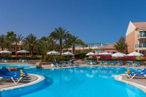 Außenpool des Mövenpick Resort & Spa El Gouna mit Loungeliegen und Sonnenschirmen.