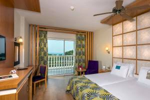 Zimmer im Defne Defnem Hotel mit Blick auf den Balkon und das Meer.