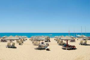 Strand mit vielen Sonnenschirmen und Liegen am Defne Defnem Hotel