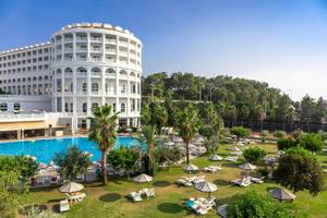 Defne Defnem Hotel Außenbereich mit Swimmingpool, Liegestühlen und Palmen.