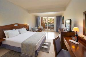 Doppelzimmer im Stella Gardens Resort & Spa Makadi Bay mit Balkon, Bett, Schreibtisch, Fernseher und Balkonzugang