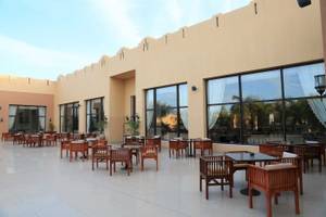 Terrasse mit Tischen und Stühlen im Stella Gardens Resort & Spa Makadi Bay