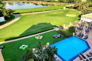 Luftaufnahme des Stella Gardens Resort & Spa Golfplatzes mit Außenbereich, Pool und Sonnenliegen.