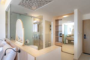 Badezimmer im Three Corners Equinox Beach Resort Hotel mit Glasdusche, Spiegel, Toilette und Waschbecken.