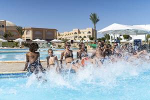 Gruppe von Kindern und Erwachsenen, die Spaß im Schwimmbecken des Three Corners Equinox Beach Resorts haben.