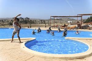 Gruppe von Menschen macht Wassergymnastik im Swimmingpool des Three Corners Equinox Beach Resort