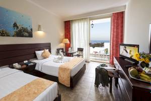 Doppelzimmer im Three Corners Equinox Beach Resort mit Meerblick, zwei Betten, Fernseher, und Balkon.