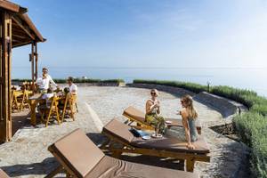 Gäste des Three Corners Equinox Beach Resorts auf einer Terrasse mit Blick auf das Meer.