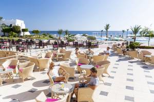 Gäste sitzen auf der Terrasse des Three Corners Equinox Beach Resorts.