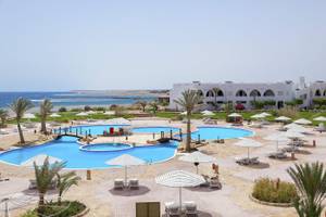 Luftaufnahme des Three Corners Equinox Beach Resorts mit Swimmingpools, Sonnenschirmen und Lounge-Stühlen.