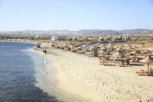 Strand des Three Corners Equinox Beach Resorts mit vielen Sonnenschirmen und Liegen.