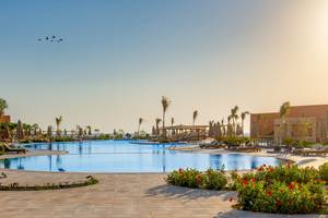 Ein Swimmingpool mit mehreren Schwimmern und Sonnenschirmen im Three Corners Happy Life Beach Resort.