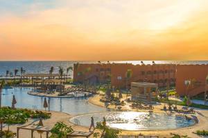 Außenbereich des Three Corners Happy Life Beach Resorts mit Swimmingpools und Sonnenliegen.