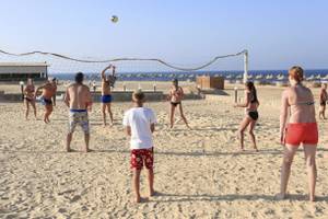 Gruppe von Männern und Frauen spielt Volleyball am Strand des Three Corners Happy Life Beach Resort