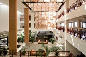 Foyer des Costa Calero Thalasso & Spa Hotels mit Sofa, Pflanzen und Marmordecke.