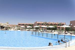 Ein Swimmingpool mit mehreren Schwimmern und Sonnenschirmen im Three Corners Happy Life Beach Resort.