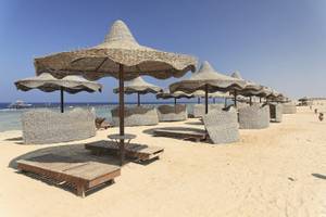 Strand mit Sonnenschirmen und Liegen im Three Corners Happy Life Beach Resort.