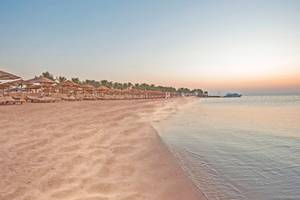 Sonnenuntergang am Strand des SUNRISE Royal Makadi Resort mit vielen Sonnenschirmen