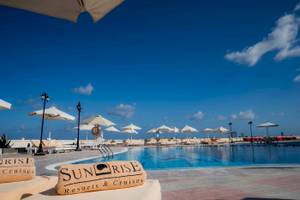 Poolbereich des Sunrise Royal Makadi Resorts mit Liegestühlen und Sonnenschirmen.