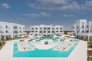 Außenbereich des Sunrise Royal Makadi Resort mit Swimmingpool und weißen Gebäuden.