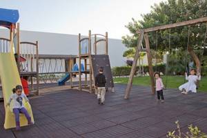 Kinder spielen auf einem Spielplatz im Freien im Costa Calero Thalasso & Spa Hotel.