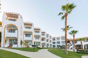 Außenansicht des Sunrise Royal Makadi Resorts mit weißen Gebäuden und Palmen
