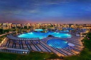 Beleuchteter Poolbereich des Sunrise Royal Makadi Resorts mit mehreren Schwimmbecken und Liegen.