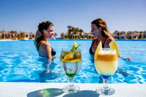Zwei Frauen im Schwimmbad mit Getränkegläsern