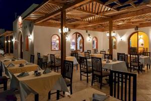 Innenansicht des Restaurants im Gorgonia Beach Resort mit gedeckten Tischen und Holzdecken.