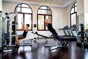 Fitness-Training im Gorgonia Beach Resort-Hotel-Gym mit zwei Personen, die verschiedene Geräte nutzen.