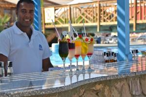 Foto von einem Barkeeper im Brayka Bay Resort, der Cocktails an der Poolbar serviert.