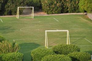 Fussballfeld im Brayka Bay Resort mit zwei Toren und umsaenumten Spielflaechen.