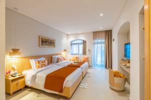 Innenansicht eines Doppelzimmers im Three Corners Rihana Resort mit zwei Betten, Dekor und Fenstern.